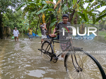 Bangladeshi people suffer from floods during heavy monsoon rains in rural Bangladesh on August 20, 2024. (