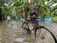 Bangladeshi people suffer from floods during heavy monsoon rains in rural Bangladesh on August 20, 2024. (