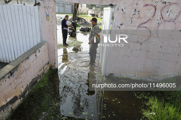 People are trying to walk on flooded streets in Chalco, State of Mexico, on August 20, 2024, where several families are being severely affec...