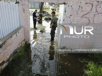 People are trying to walk on flooded streets in Chalco, State of Mexico, on August 20, 2024, where several families are being severely affec...