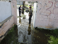 People are trying to walk on flooded streets in Chalco, State of Mexico, on August 20, 2024, where several families are being severely affec...