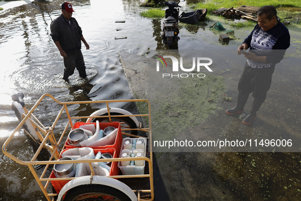 People are trying to walk on flooded streets in Chalco, State of Mexico, on August 20, 2024, where several families are being severely affec...