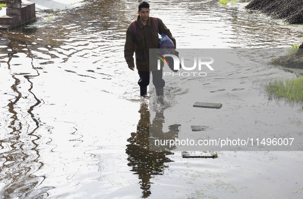 People are trying to walk on flooded streets in Chalco, State of Mexico, on August 20, 2024, where several families are being severely affec...