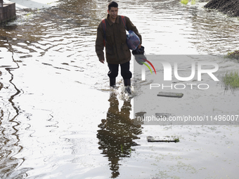 People are trying to walk on flooded streets in Chalco, State of Mexico, on August 20, 2024, where several families are being severely affec...