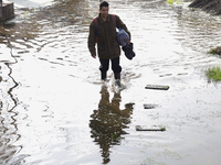 People are trying to walk on flooded streets in Chalco, State of Mexico, on August 20, 2024, where several families are being severely affec...