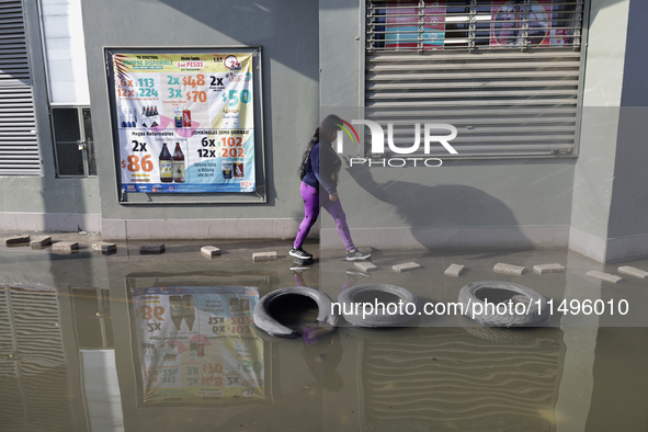 People are trying to walk on flooded streets in Chalco, State of Mexico, on August 20, 2024, where several families are being severely affec...