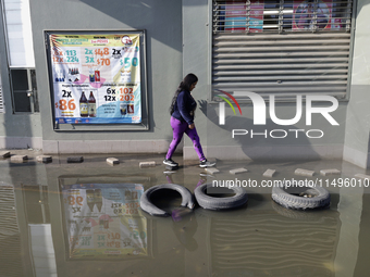 People are trying to walk on flooded streets in Chalco, State of Mexico, on August 20, 2024, where several families are being severely affec...