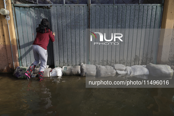 People are trying to walk on flooded streets in Chalco, State of Mexico, on August 20, 2024, where several families are being severely affec...