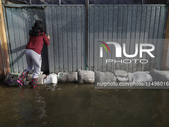 People are trying to walk on flooded streets in Chalco, State of Mexico, on August 20, 2024, where several families are being severely affec...