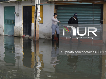 People are trying to walk on flooded streets in Chalco, State of Mexico, on August 20, 2024, where several families are being severely affec...