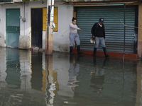 People are trying to walk on flooded streets in Chalco, State of Mexico, on August 20, 2024, where several families are being severely affec...