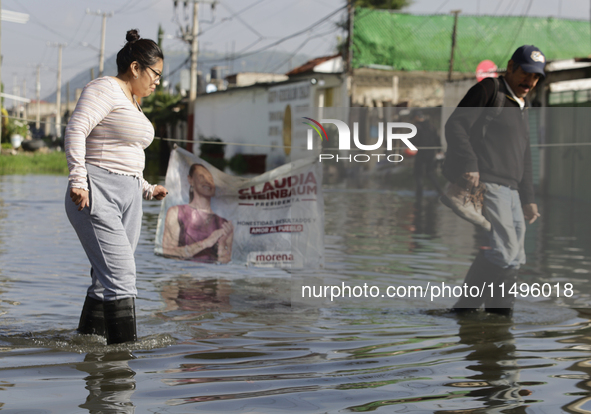 People are trying to walk on flooded streets in Chalco, State of Mexico, on August 20, 2024, where several families are being severely affec...