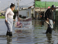 People are trying to walk on flooded streets in Chalco, State of Mexico, on August 20, 2024, where several families are being severely affec...