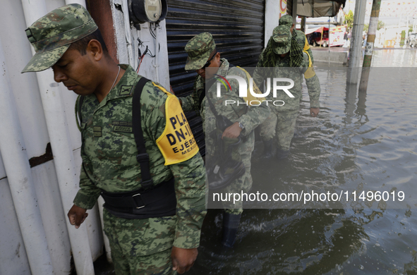 Members of the Mexican army are trying to walk on flooded streets in Chalco, State of Mexico, on August 20, 2024, where several families are...