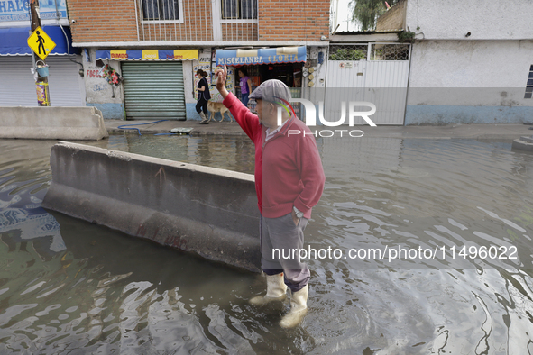 People are trying to walk on flooded streets in Chalco, State of Mexico, on August 20, 2024, where several families are being severely affec...