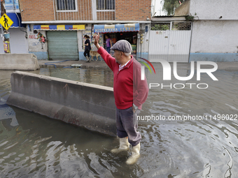 People are trying to walk on flooded streets in Chalco, State of Mexico, on August 20, 2024, where several families are being severely affec...