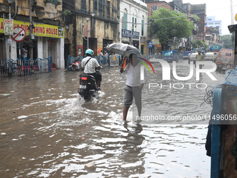 Commuters are walking on a busy water-logged street after heavy monsoon rain in Kolkata, India, on August 20, 2024. (