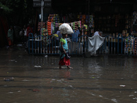 A woman is walking on a busy water-logged street after heavy monsoon rain in Kolkata, India, on August 20, 2024. (