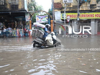 A man is riding his two-wheeler through a water-logged street after heavy monsoon rain in Kolkata, India, on August 20, 2024. (