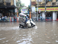 A man is riding his two-wheeler through a water-logged street after heavy monsoon rain in Kolkata, India, on August 20, 2024. (