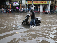 A man is pushing   two-wheeler through a water-logged street after heavy during monsoon rain in Kolkata, India, on August 20, 2024. (