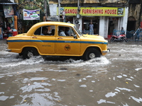 A taxi is driving through a water-logged street after heavy monsoon rain in Kolkata, India, on August 20, 2024. (