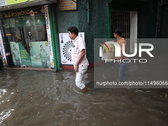 A man is walking beside a water-logged street after heavy monsoon rain in Kolkata, India, on August 20, 2024. (