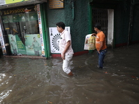 A man is walking beside a water-logged street after heavy monsoon rain in Kolkata, India, on August 20, 2024. (