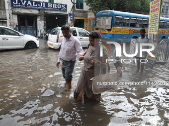 Commuters are walking on a busy water-logged street after heavy monsoon rain in Kolkata, India, on August 20, 2024. (