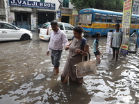 Commuters are walking on a busy water-logged street after heavy monsoon rain in Kolkata, India, on August 20, 2024. (