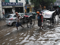 Rickshaw pullers are making their way through a water-logged street after heavy monsoon rain in Kolkata, India, on August 20, 2024. (