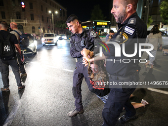 Israeli police officers are moving demonstrators blocking a street during a protest in Jerusalem, Israel, on August 20, 2024. People are gat...