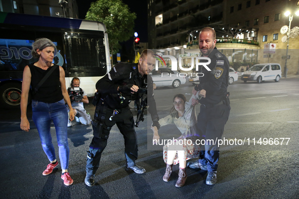 Israeli police officers are moving demonstrators blocking a street during a protest in Jerusalem, Israel, on August 20, 2024. People are gat...