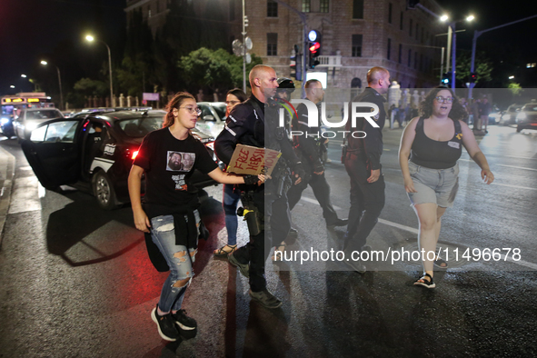 Israeli police officers are moving demonstrators blocking a street during a protest in Jerusalem, Israel, on August 20, 2024. People are gat...