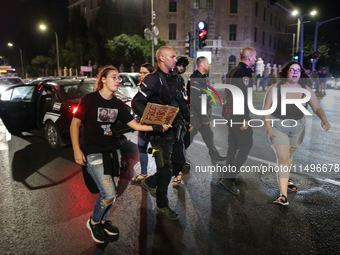 Israeli police officers are moving demonstrators blocking a street during a protest in Jerusalem, Israel, on August 20, 2024. People are gat...