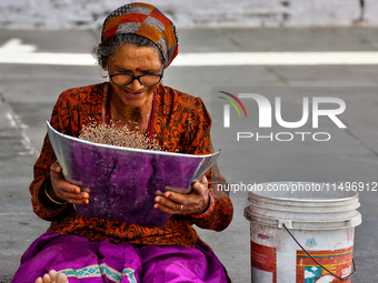 A woman is winnowing grain in the Sainji Village (Corn Village) in Mussoorie, Uttarakhand, India, on April 18, 2024. This village is famous...