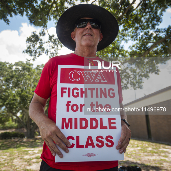 Unionized workers are picketing near the entrance of an AT&T facility in Daytona Beach, Florida, on August 20, 2024, as part of the Communic...