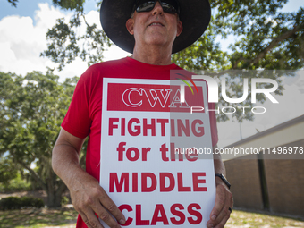 Unionized workers are picketing near the entrance of an AT&T facility in Daytona Beach, Florida, on August 20, 2024, as part of the Communic...