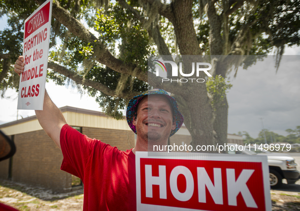 Unionized workers are picketing near the entrance of an AT&T facility in Daytona Beach, Florida, on August 20, 2024, as part of the Communic...