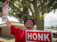 Unionized workers are picketing near the entrance of an AT&T facility in Daytona Beach, Florida, on August 20, 2024, as part of the Communic...