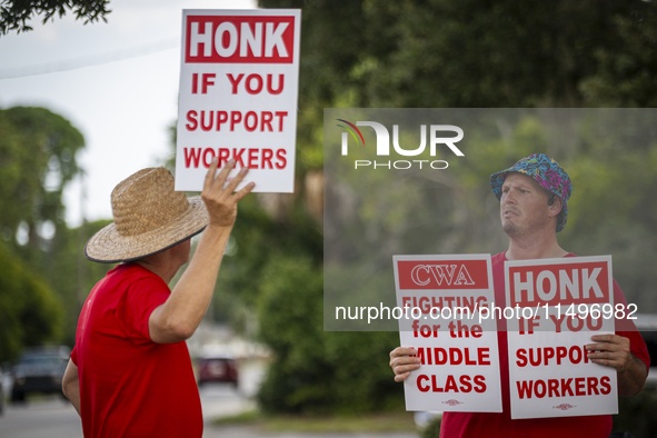 Unionized workers are picketing near the entrance of an AT&T facility in Daytona Beach, Florida, on August 20, 2024, as part of the Communic...