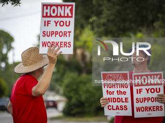 Unionized workers are picketing near the entrance of an AT&T facility in Daytona Beach, Florida, on August 20, 2024, as part of the Communic...