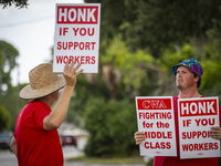 Unionized workers are picketing near the entrance of an AT&T facility in Daytona Beach, Florida, on August 20, 2024, as part of the Communic...