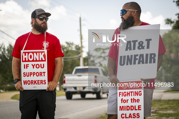 Unionized workers are picketing near the entrance of an AT&T facility in Daytona Beach, Florida, on August 20, 2024, as part of the Communic...