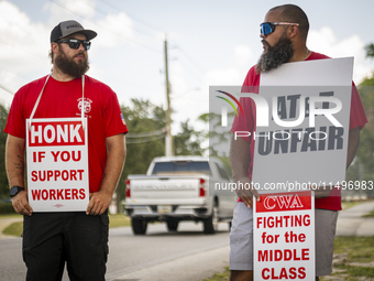 Unionized workers are picketing near the entrance of an AT&T facility in Daytona Beach, Florida, on August 20, 2024, as part of the Communic...