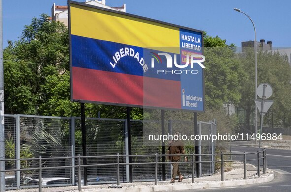 A person is walking near a billboard with the inscription in Spanish ''Venezuela Libre'' (free Venezuela) in the center of Lisbon, Portugal,...