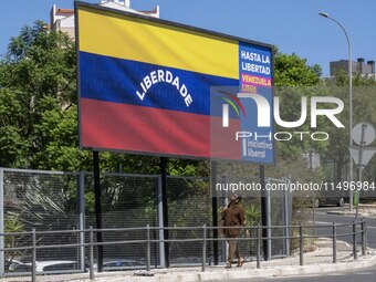 A person is walking near a billboard with the inscription in Spanish ''Venezuela Libre'' (free Venezuela) in the center of Lisbon, Portugal,...