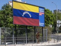 A person is walking near a billboard with the inscription in Spanish ''Venezuela Libre'' (free Venezuela) in the center of Lisbon, Portugal,...