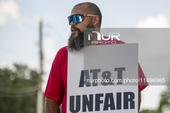 Unionized workers are picketing near the entrance of an AT&T facility in Daytona Beach, Florida, on August 20, 2024, as part of the Communic...