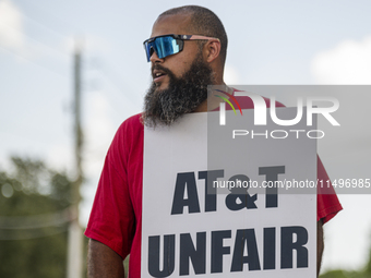 Unionized workers are picketing near the entrance of an AT&T facility in Daytona Beach, Florida, on August 20, 2024, as part of the Communic...